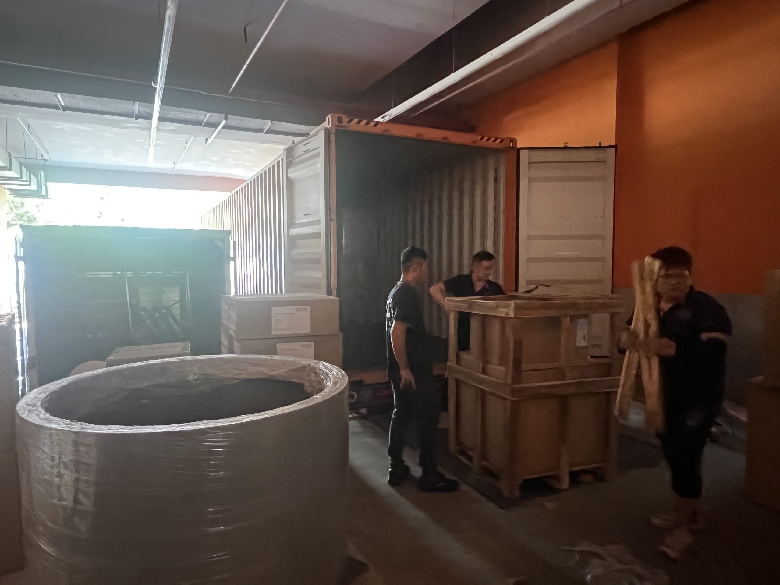 Move Move Movers crew unloading a wooden crate and wrapped commercial item from a shipping container