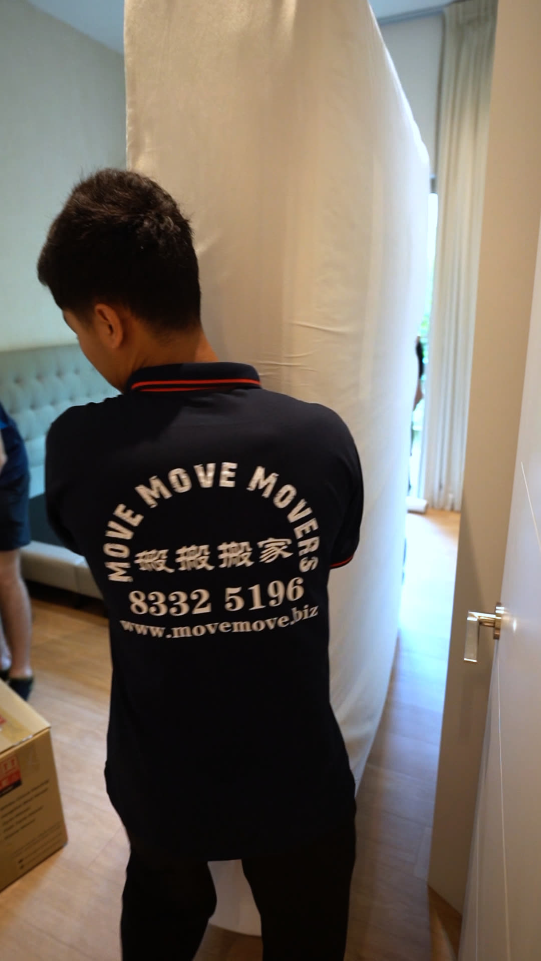 Wrapped mattress being carried out for disposal in Singapore